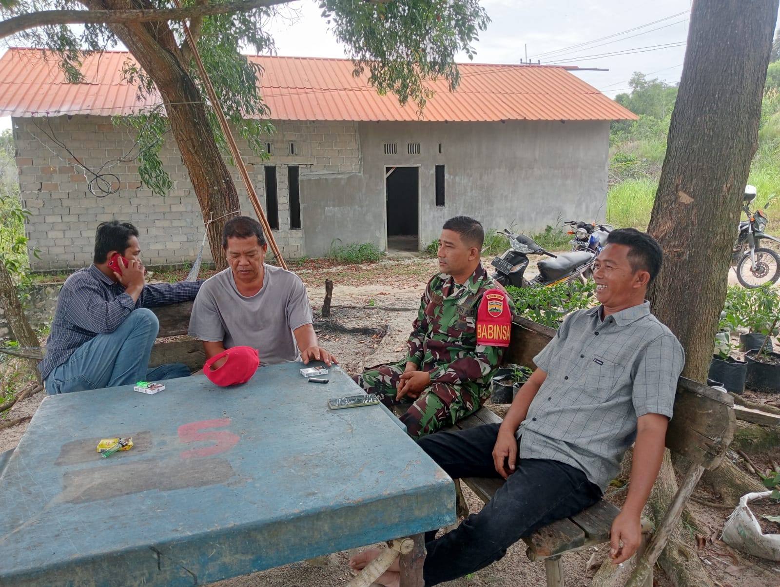 Serda Efin Wijaya, Babinsa Desa Pongkar dari Koramil 04/Tebing Kodim 0317/TBK, melaksanakan kegiatan Komsos dengan warga RW 02 Desa Pongkar.