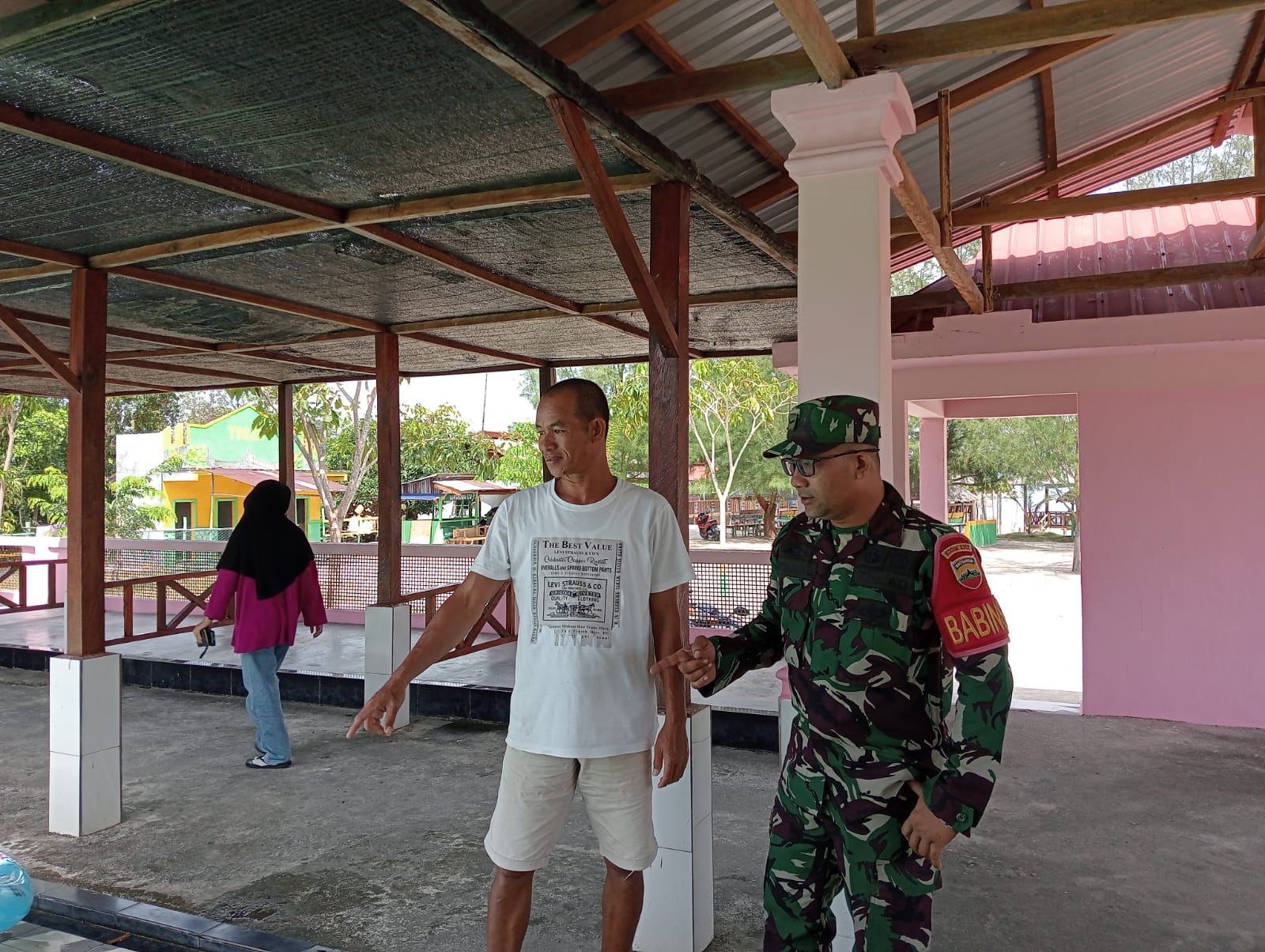 Babinsa Desa Pongkar, Serda Efin Wijaya Komsos dengan Muslim, pemilik kolam renang yang berlokasi di Pantai Ketam, Desa Pongkar.