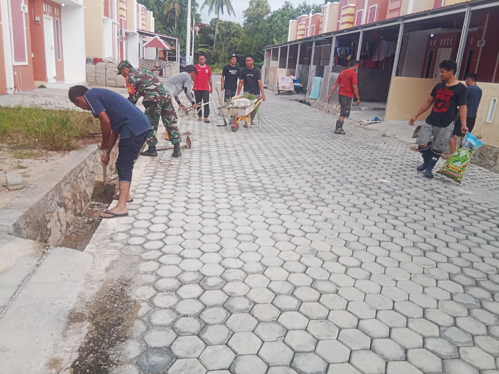 Babinsa Kelurahan Tebing, Sertu Hendra Gunawan gotong royong bersama warga Perumahan Rangam Asri RT 01/RW 01, Ranggam.