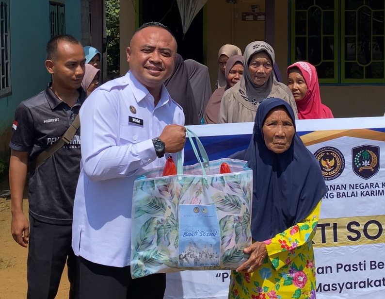 Kepala Rutan Kelas IIB Tanjung Balai Karimun, Yoga Hadhi Wijaya menyerahkan paket sembako kepada warga Desa Gemuruh melalui bakti sosial.