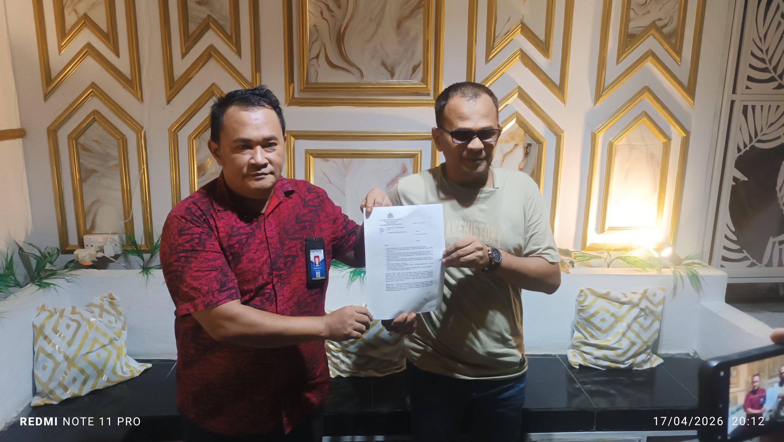Ahmad Iskandar Tanjung atau Tanjung Buser) (kanan) didampingi kuasa hukumnya, Ilfan Rambe (kiri) saat menunjukkan Surat Pemberitahuan Penghentian Penyelidikan (SP2Lid) dari pihak kepolisian. (Foto: Porosterkini.com)
